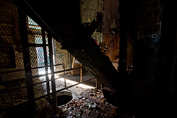 abandoned factory interior with light from doorway and metal structures