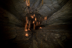 intérieur de grotte en perspective avec lumière sur stalactites et stalagmites
