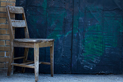 chair in front of door with graffiti