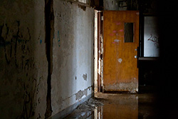 abandoned school hallway with water on floor and reflection