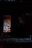 doorway in dark room with damaged wall