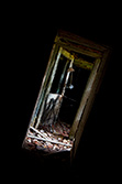lumière dans encadrement de porte dans salle sombre de maison abandonnée