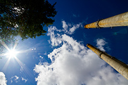 cheminées d'usine avec soleil dans ciel avec nuages