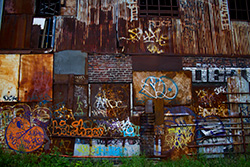 rusty plates and corrugated iron wall with graffiti
