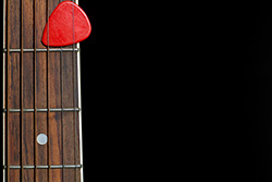 plectrum on guitar with strings and fingerboard