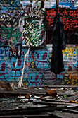 manteau sale suspendu dans salle démolie avec mur de graffiti