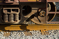 rusty wagon wheel on rails and gravels