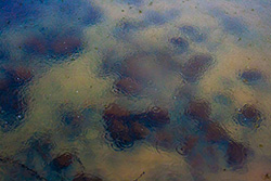 gouttes de pluie sur l'eau d'un lac avec des rocher au fond