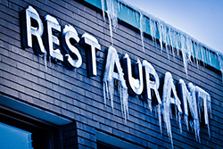 frozen restaurant sign in winter with stalactites