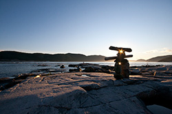Inuksuk dans baie de Tadousac, Québec, coucher de soleil sur le Saint Laurent