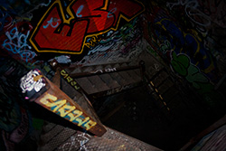 cage d'escalier sombre dans bâtiment abandonné avec graffiti