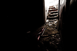 escaliers lumineux dans salle sombre de maison abandonnée