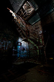 rusty stairs and graffiti in derelict factory building with light painting